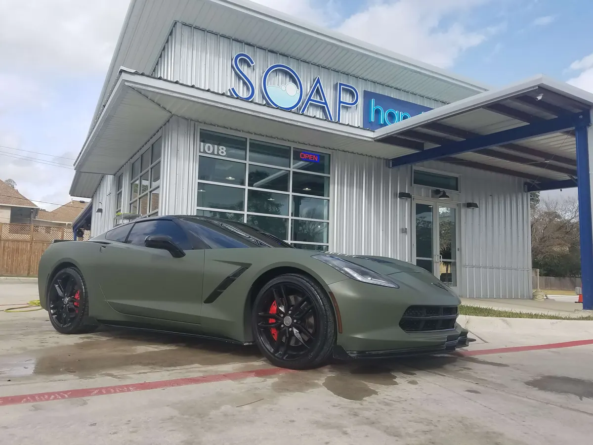 Matte green Corvette in front of the SOAP Hand Car Wash storefront