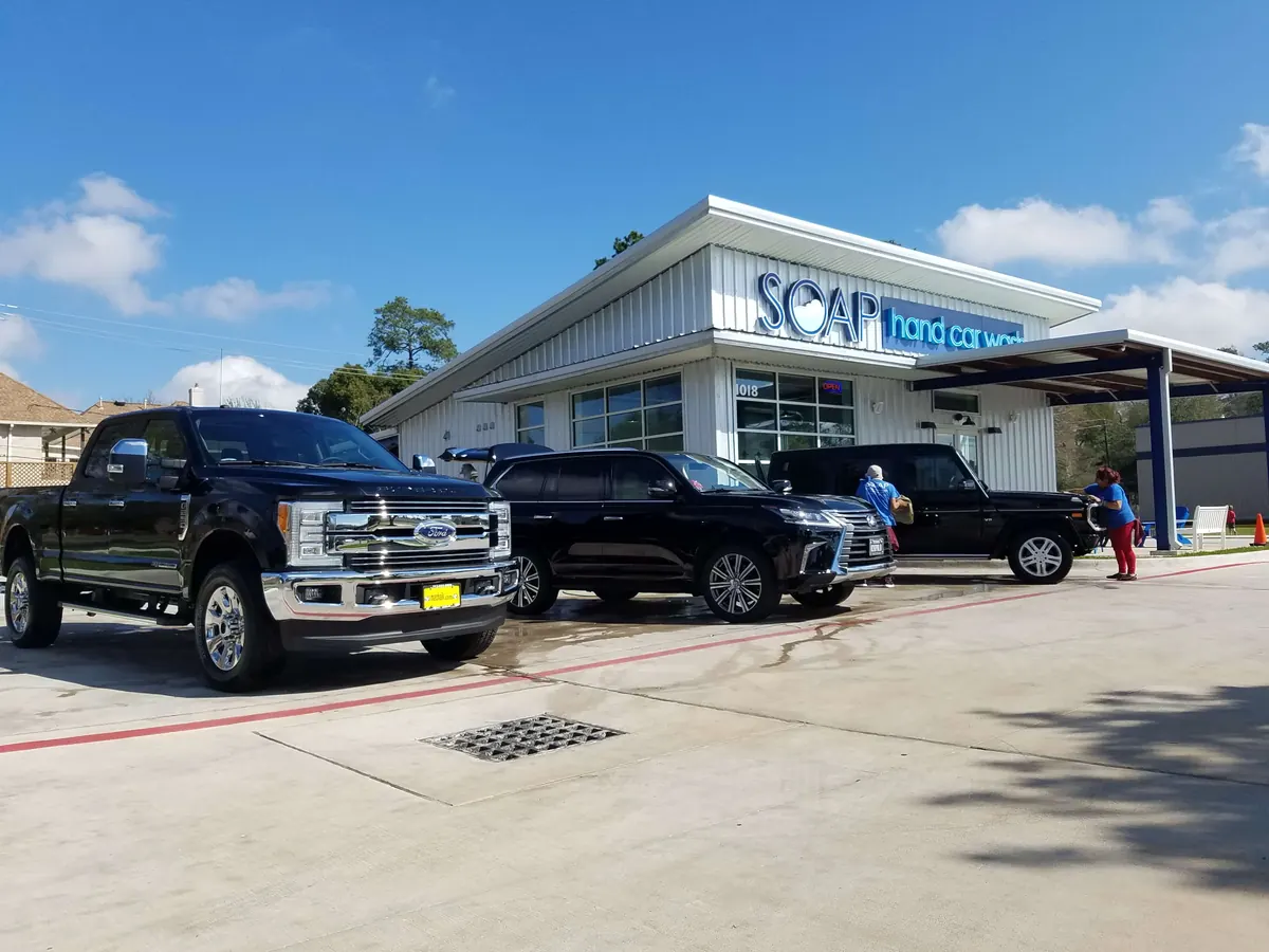Black Ford pickup and SUVs being hand washed at a SOAP location