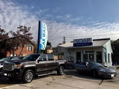 Black GMC pickup truck and a convertible outside a SOAP storefront