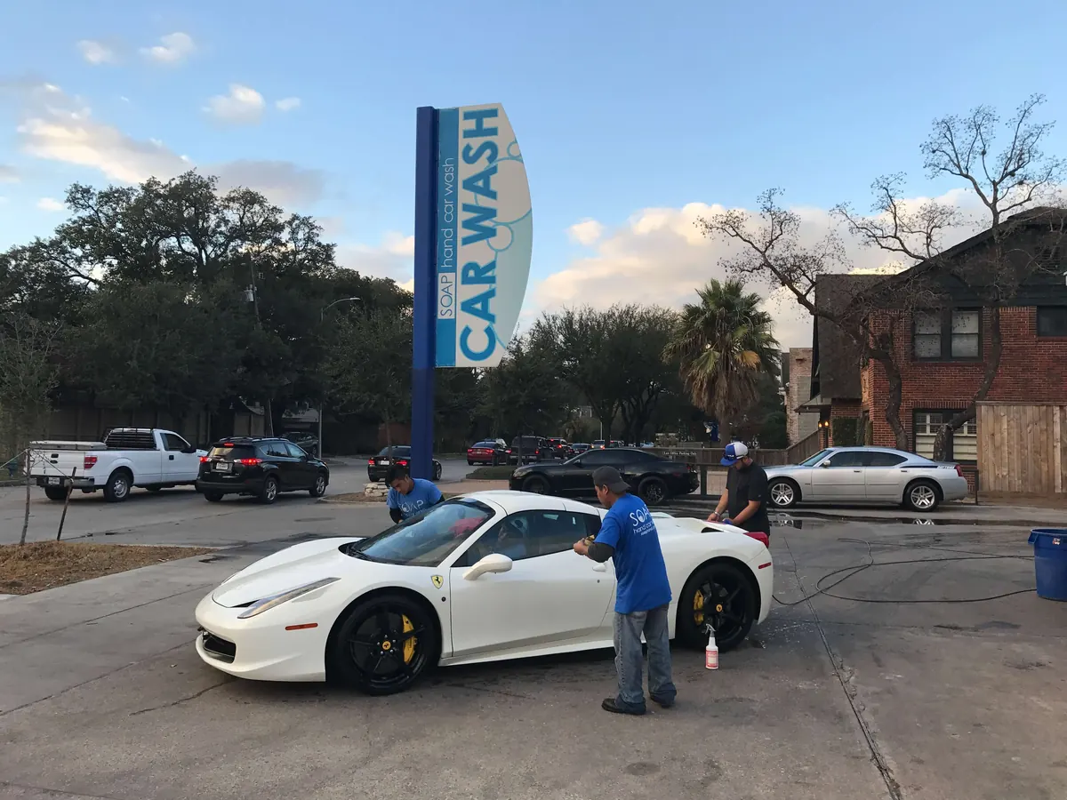 SOAP crew hand washing a white Ferrari 458