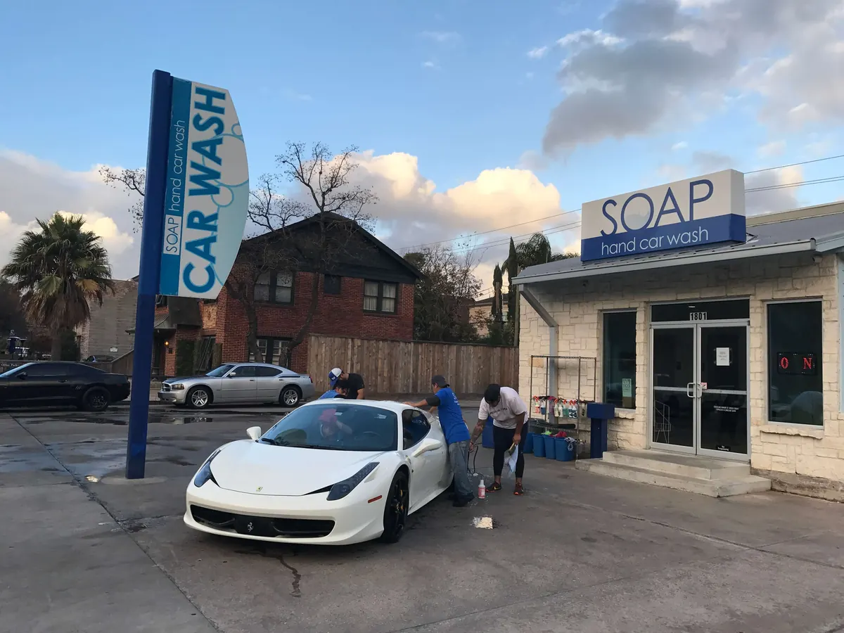 White Ferrari 458 outside a SOAP Hand Car Wash storefront