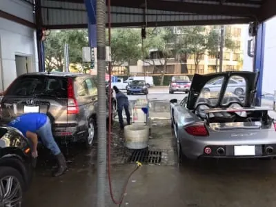 Crew washing cars inside a covered SOAP wash bay