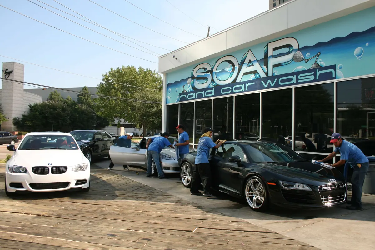 SOAP crew hand washing a black Audi R8 and a white BMW