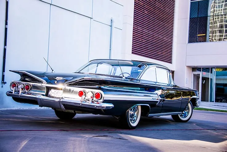 Black classic Chevrolet Impala with whitewall tires after a hand wash